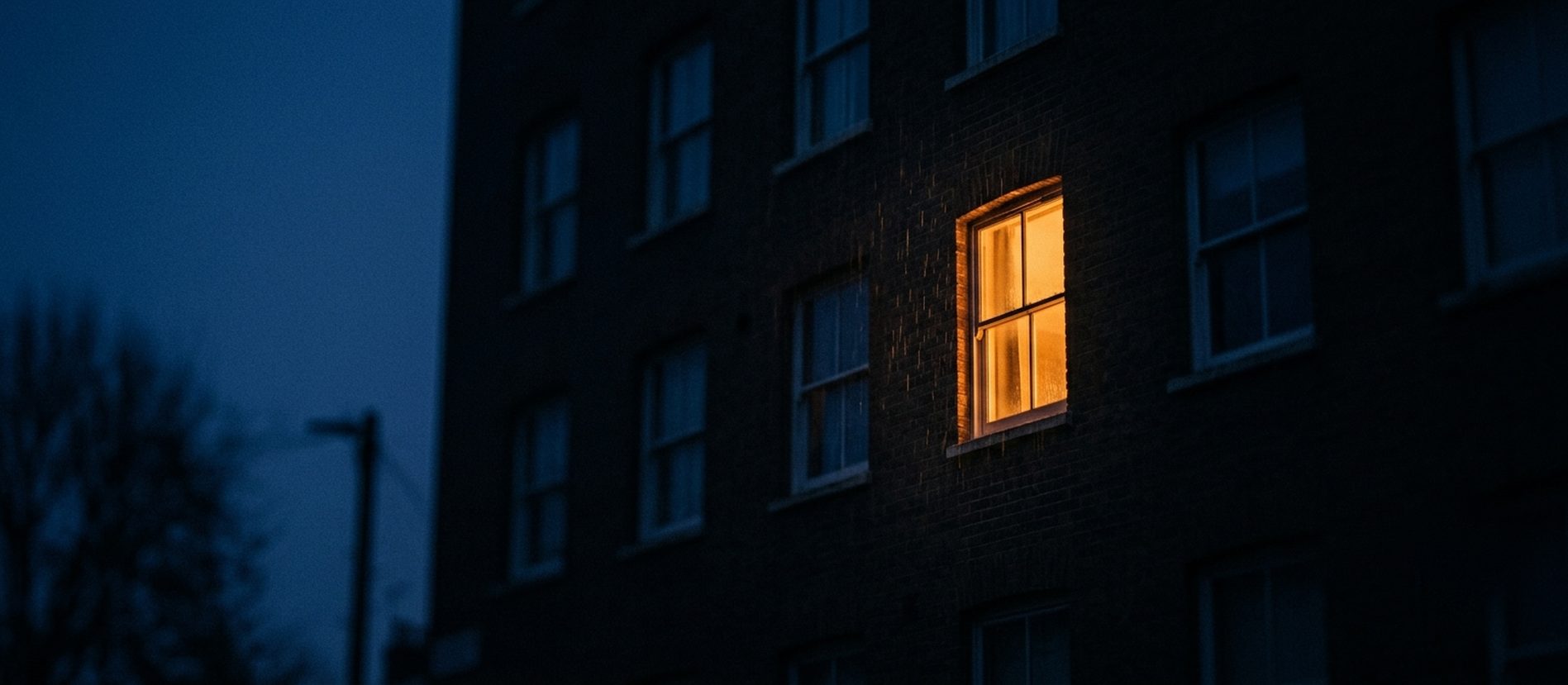Een verlicht raam in de schemering - eenzaamheid als signaal